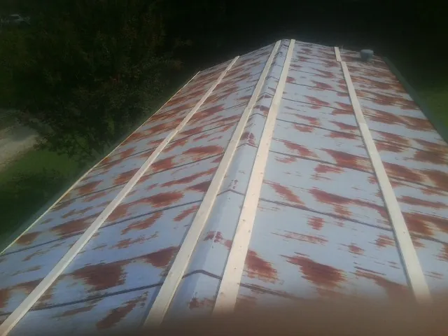 Rusted metal roof panels with new wood purlins before replacement — Storm Damage Roof Repair in Allenhurst by Roofing Brothers