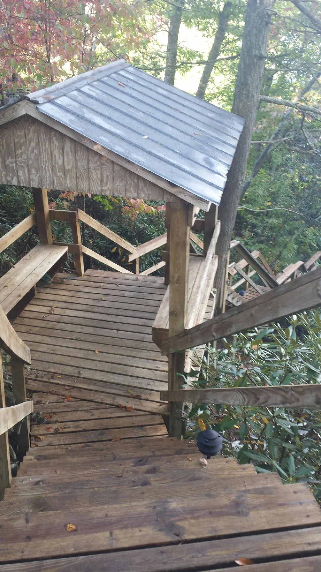 Metal roofed shelter over wooden steps on a wooded walkway — Skylight Repair & Installation work by our crew in Allenhurst